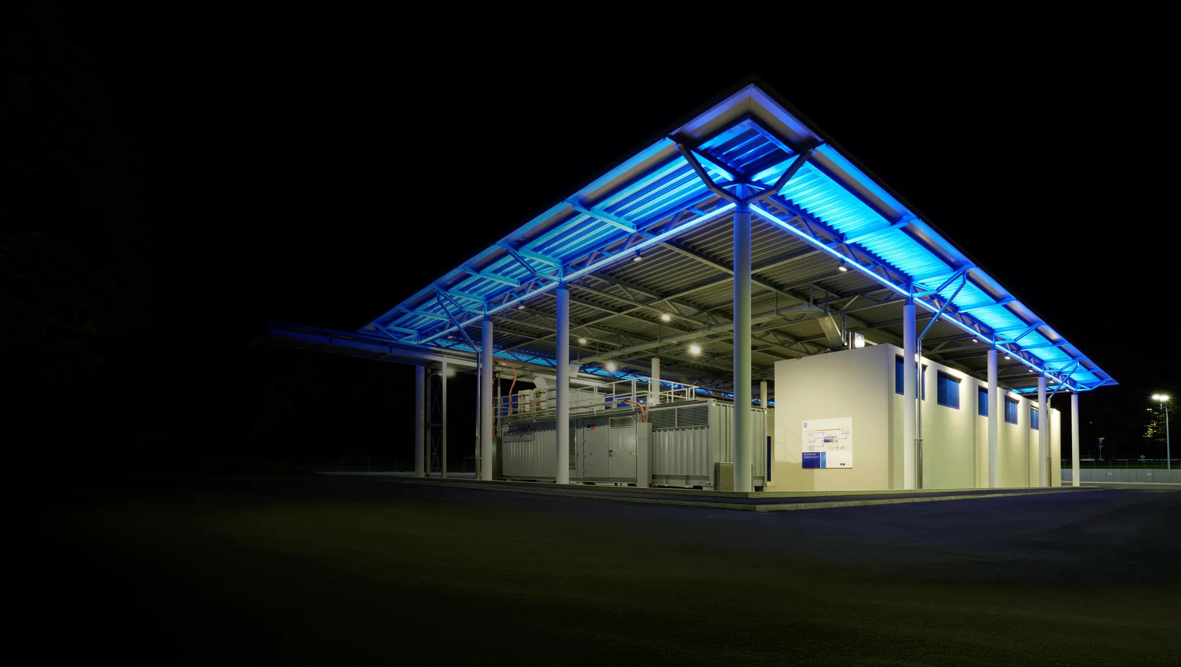 A Rolls-Royce facility lit in blue at night